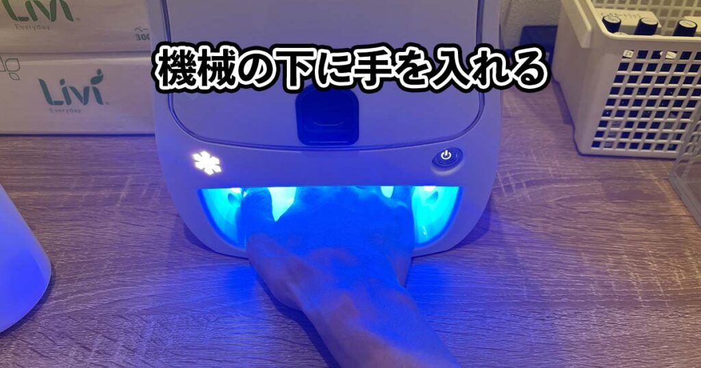 機械の下に手を入れる