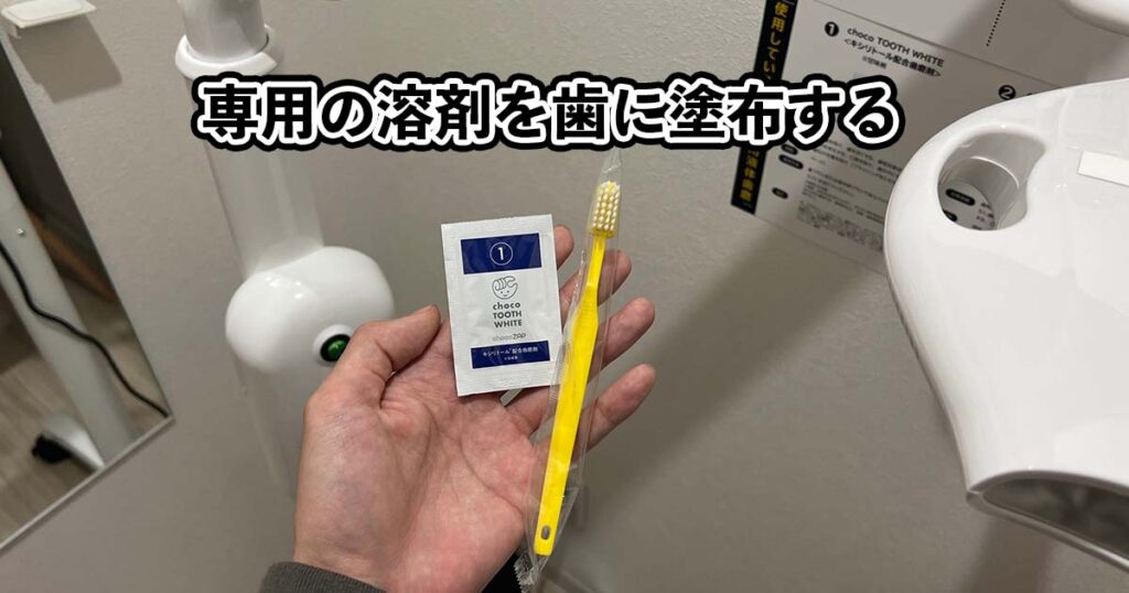 筆者が専用溶剤と歯ブラシを手のひらに置いている