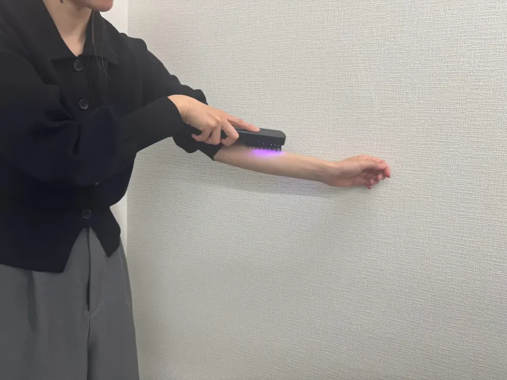 エレキブラシを腕に当てている様子